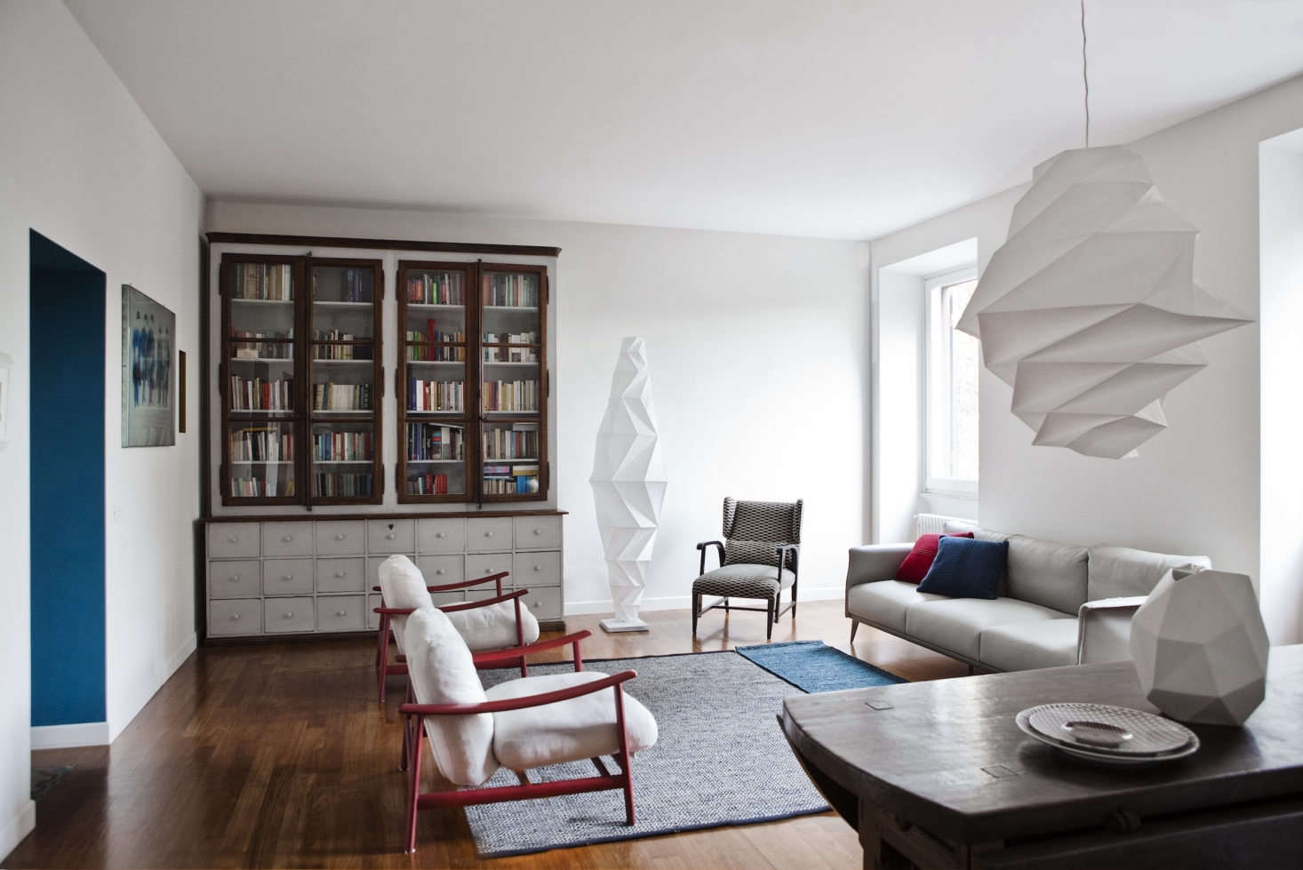The sculptural living room is grounded by a massive hutch, the family