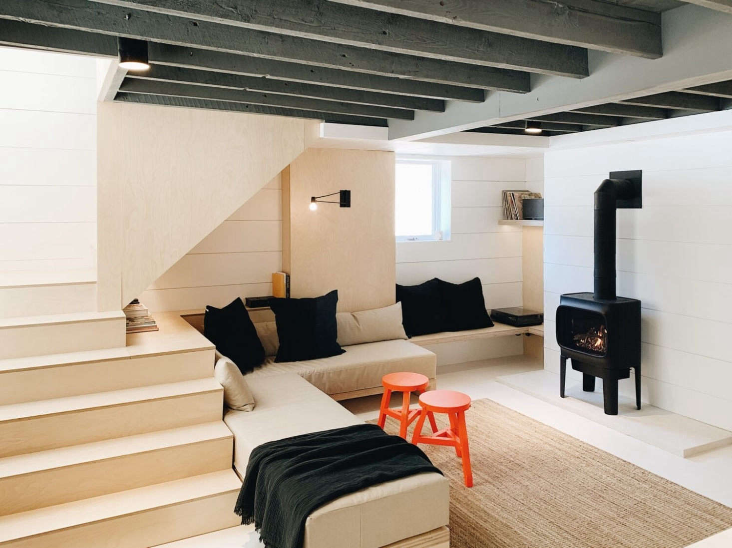 The previous owners had installed a second story, but left the downstairs untouched. Working with a local crew—carpenter, electrician, and plumber—Kristin and Doug created an open plan and exposed the beams (which are painted the same charcoal gray as the exterior).