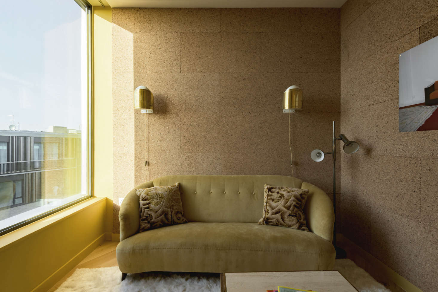 A small, cork-lined room off the kitchen serves as a sitting room/study; the three-seater sofa is upholstered in mustard corduroy.