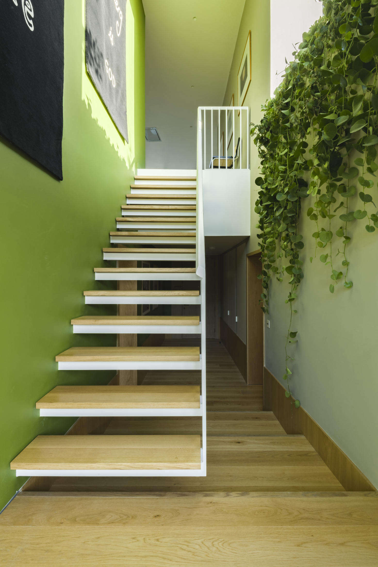 A floating staircase leads to the lower bedroom level.