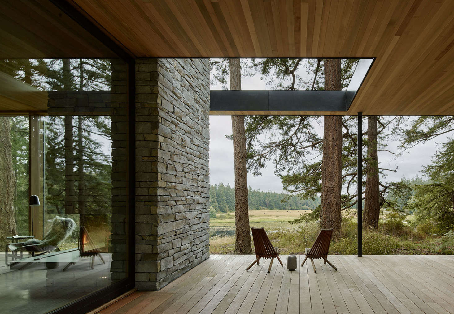 On the deck, the fireplace transitions into a stone wall. A cutout in the roof allows for more light.