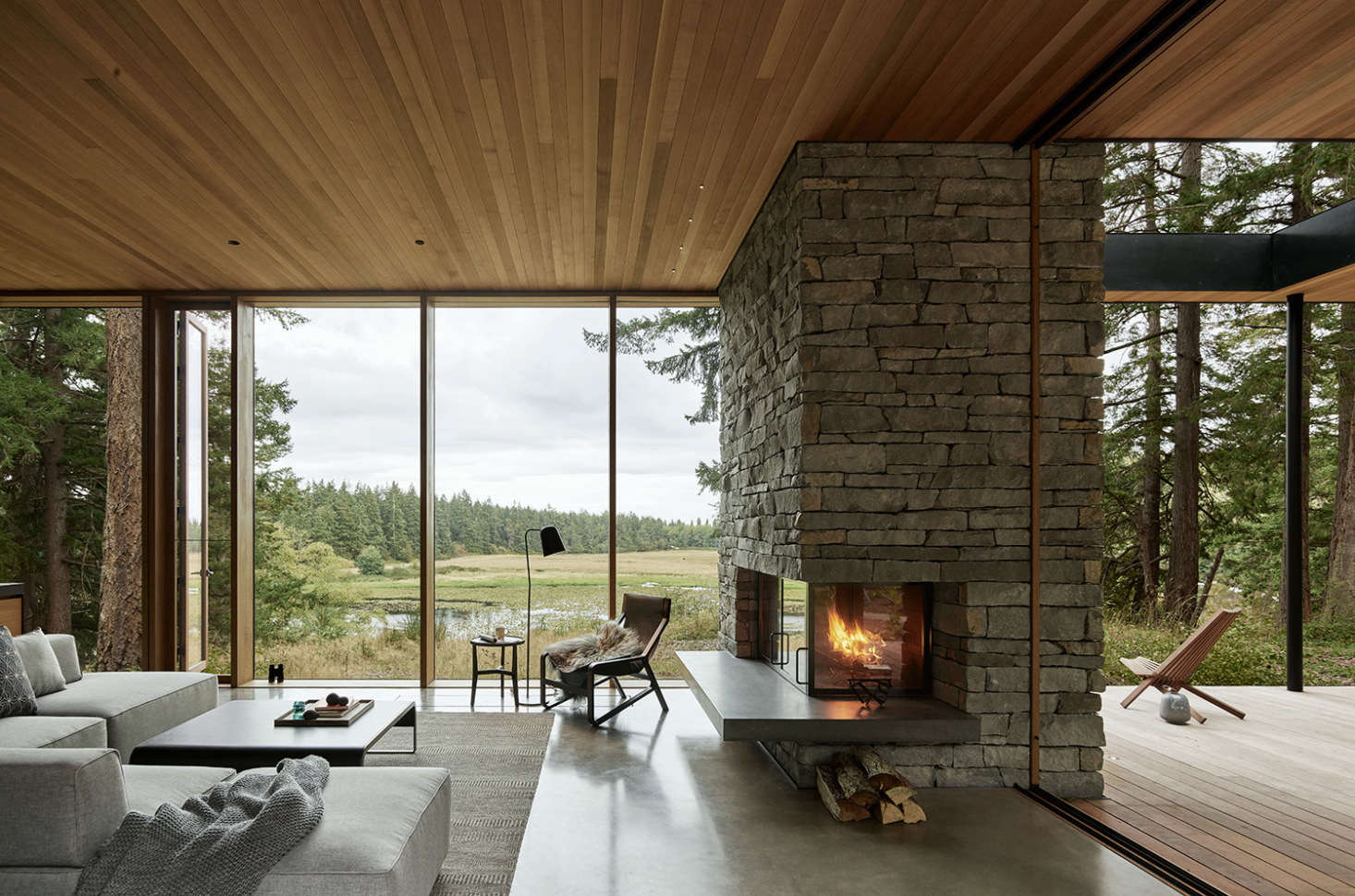 A portion of the stone fireplace rests on the deck just off the living room, blurring the line between indoors and out.