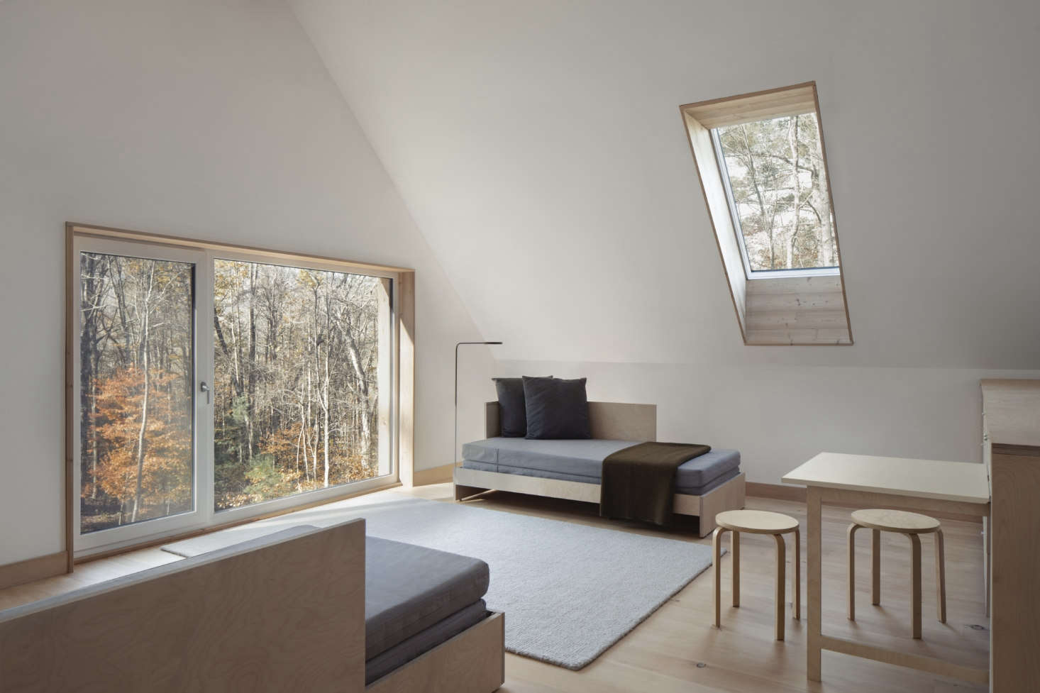 Accessed by a stair, the loft on the southern end of the house is furnished with daybeds of cabinet-grade birch ply that Maria and Todd designed for the space. They can be moved together to form a larger bed.