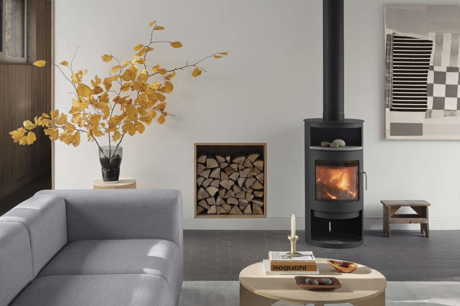 A Rondo stove by Rais supplements sub-floor radiant heating. (The niche is filled with logs from the cleared trees on the property.) 